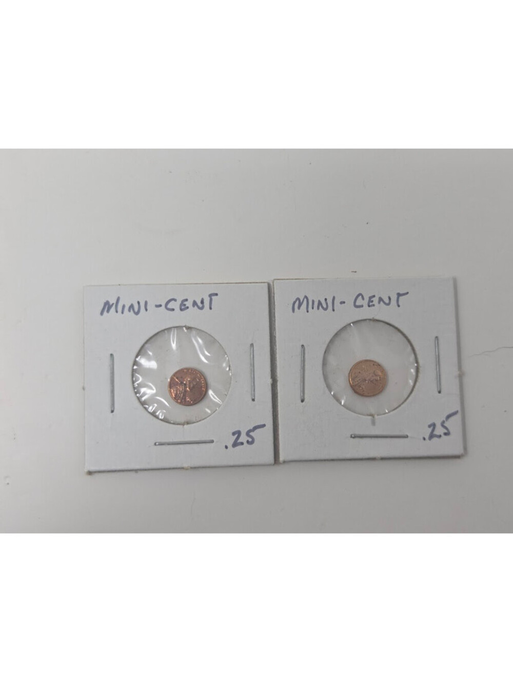 Two Miniature Mini Cent Tokens Mounted in Card Holders With Protective Plastic